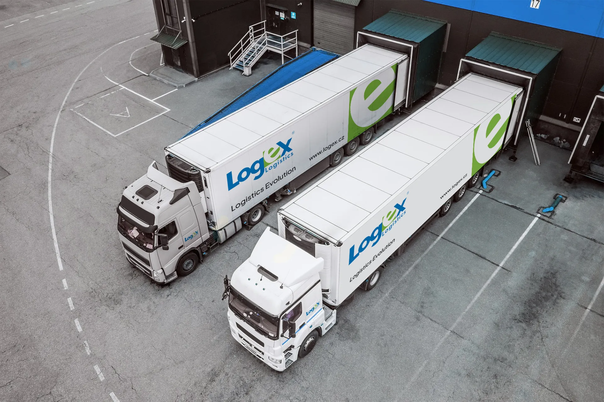 Logex dva kamiony u skladové haly. Kamionová doprava.